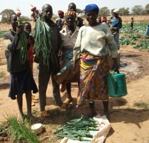 Family in Burkina Faso with vegetables harvested from garden